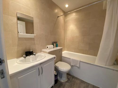 La salle de bains est pourvue d'un lavabo, de toilettes et d'une baignoire. dans l'établissement Stylish Central Escape, à Londres