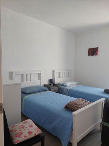 a bedroom with two beds and a chair at Quinto Canto Moneglia in Moneglia
