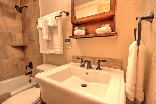 a bathroom with a sink and a toilet and towels at Yellowstone Gateway Inn in Gardiner