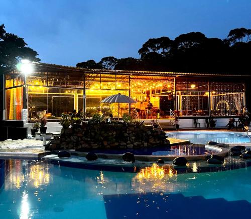 un edificio con piscina por la noche en Ecopark Hosteria Puyo, en Puyo