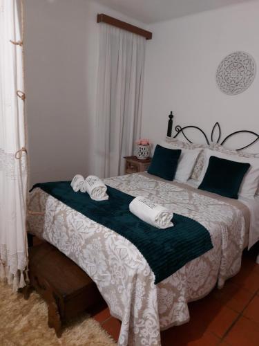 a bedroom with a bed with two towels on it at A Casinha da Vila in Vila Viçosa