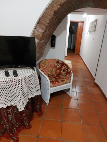 a living room with a table and a chair at A Casinha da Vila in Vila Viçosa