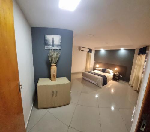 a bedroom with a bed and a table with a lamp at Hermoso Departamento - Excelente Ubicación in Ciudad del Este