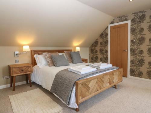 een slaapkamer met een groot bed met een houten hoofdeinde bij Whitehouse Woodwrae in Forfar