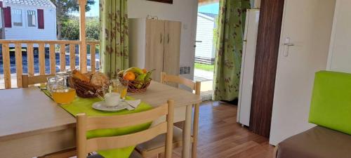 un comedor con una mesa con un bol de fruta en Bungalow T3 V - 15 Min From Nazaré, en Pataias