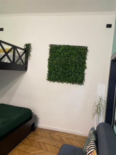 a living room with a green hedge on the wall at Green Vibes Central Brasov in Braşov