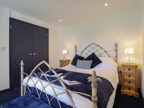 a bedroom with a bed with blue pillows on it at Bryn Eglwys Cottage in Tywyn