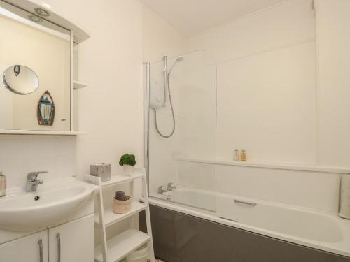 a white bathroom with a shower and a sink at Quayside in Dartmouth