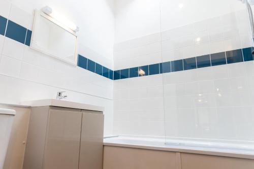 a kitchen with blue and white tiles on the wall at Warren Cottage in Little Torrington