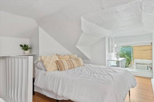 een witte slaapkamer met een wit bed en een raam bij Unit 8: Lovely updated apartment! in Billings