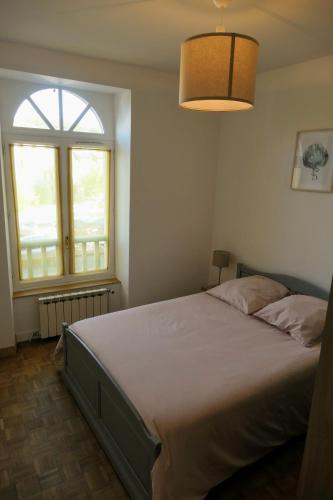 une chambre avec un grand lit et une grande fenêtre dans l'établissement Appartement cosy entièrement rénové, à Bagnères-de-Bigorre