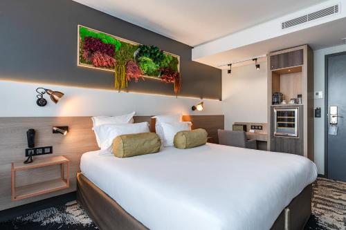 パリにあるHôtel B55の大きなベッドとキッチンが備わるホテルルームです。