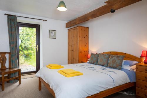 a bedroom with a large bed and a window at Tarquol Cottage in Little Torrington