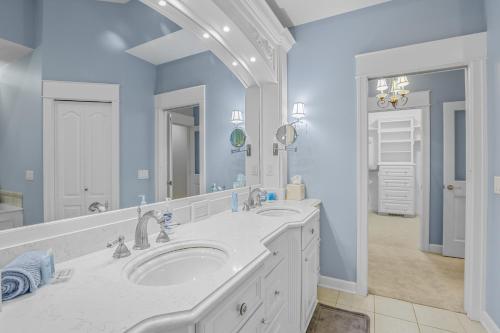 a bathroom with two sinks and a large mirror at Indoor Pool near Grand Haven with Lake Michigan Beach! in Norton Shores