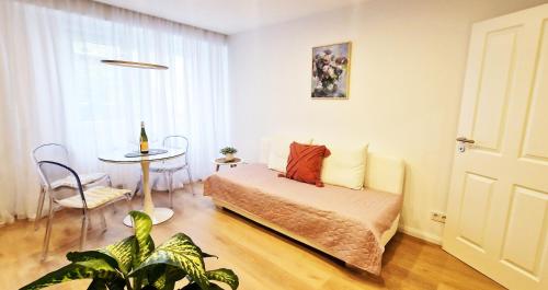 a bedroom with a bed and a table and a window at Greenline by Gregory - Apartment mit Garten in Mainz, ZDF Nähe in Mainz