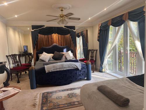 um quarto com uma cama azul e uma ventoinha de tecto em Reemdale Manor - Fulwood Row Preston PR25RW em Grimsargh