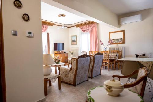 a living room with chairs and a dining room at Roula's Cosy Home in Tríkala