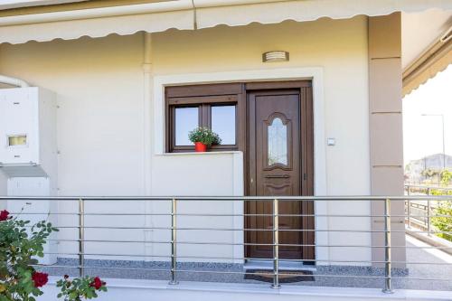 a house with a wooden door and a balcony at Roula's Cosy Home in Tríkala