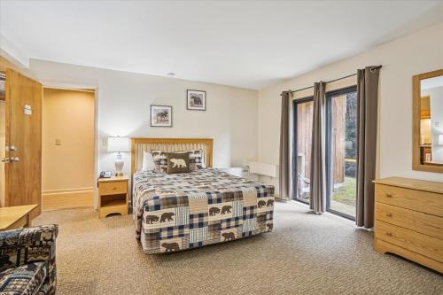 1 dormitorio con 1 cama y 1 sofá en Cedarbrook Deluxe Two Bedroom Suite with outdoor heated pool 10708, en Killington