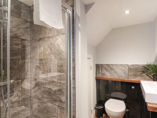 ein Bad mit einer Dusche und einem WC in der Unterkunft The Pheasantry in Bridlington