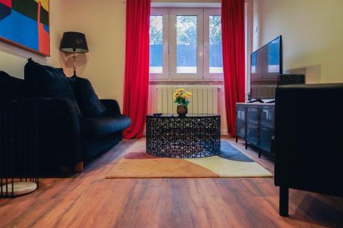 a living room with a couch and red curtains at FLH Alcântara Stylish Duplex with Terrace in Lisbon