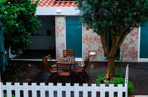 a table and chairs in front of a house with a fence at FLH Alcântara Stylish Duplex with Terrace in Lisbon