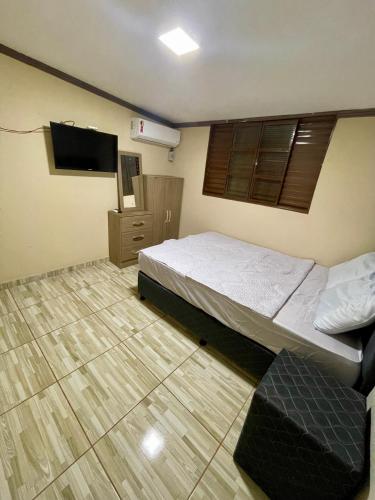 1 dormitorio con 1 cama y TV de pantalla plana en Rancho do Sossego, en Ponta Porã
