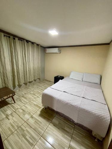 um quarto com uma cama branca num quarto em Rancho do Sossego em Ponta Porã