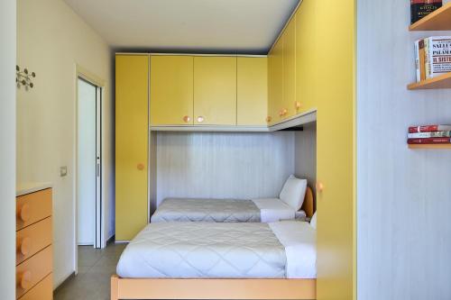 a small bedroom with two beds and yellow cabinets at Mabellini Lifestyle in Fano