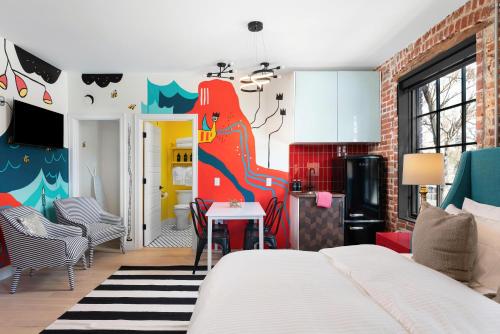 a bedroom with a bed and a kitchen with a table at The Acoma House in Denver