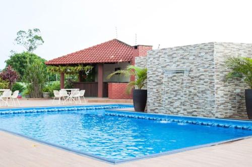 a swimming pool in front of a house at Marion Pantanal Hotel in Várzea Grande