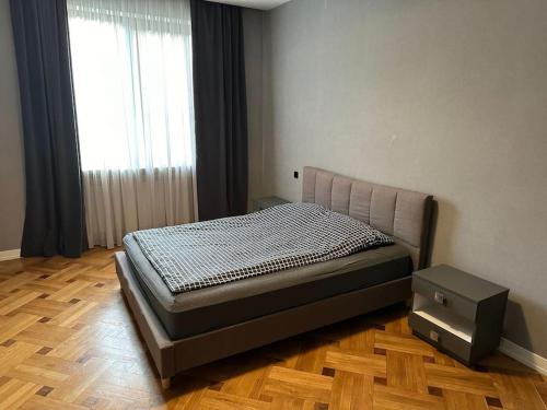 a bedroom with a bed in a room with a window at Panoramic View Apart Vera 67 in Tbilisi City