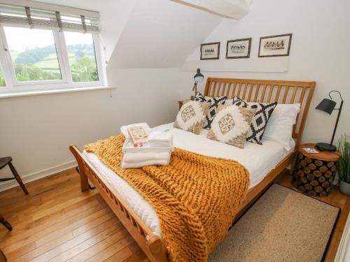 a bedroom with a bed with a blanket and a window at Pen Y Groes in Welshpool