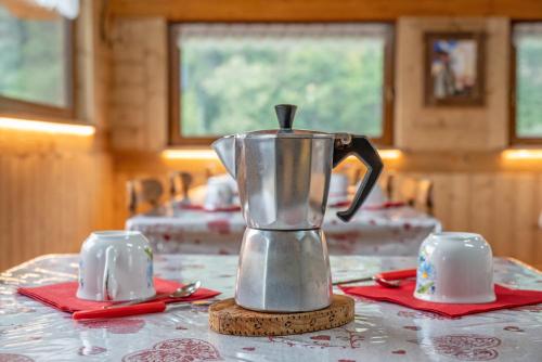 a coffee pot sitting on a table with red napkins at Agriturismo La Clochette in Torgnon