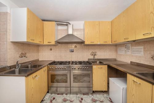 Una cocina con gabinetes de madera y un horno de estufa. en Agriturismo La Clochette, en Torgnon