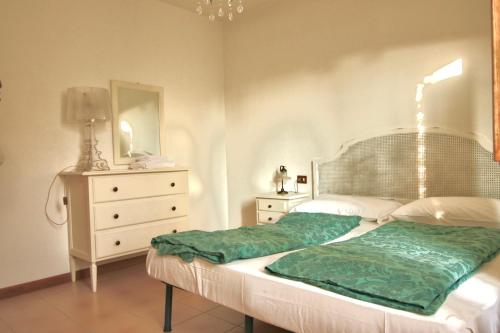 sypialnia z łóżkiem, komodą i lustrem w obiekcie 3 rooms apartment whit balcony and lake wiew w mieście Malcesine