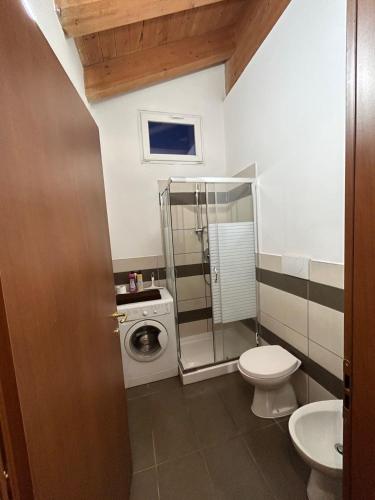 a bathroom with a toilet and a washing machine at Vacanze Sportive in La Cassa