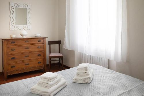 - une chambre avec un lit et des serviettes blanches dans l'établissement A Casa di Anna, à Lucques