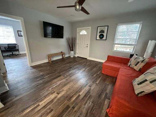 a living room with a red couch and wooden floors at Elegant 1 Bdr Montrose-Bologna@The Italian Plaza in Houston