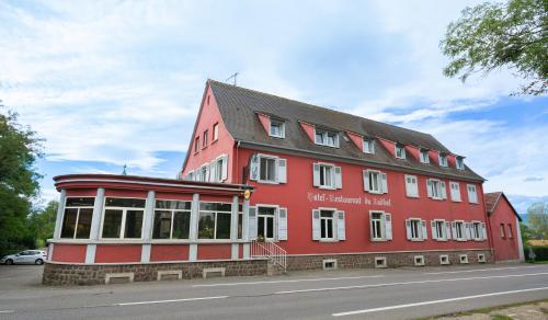 a red building sitting on the side of a street at Hôtel du Ladhof in Colmar