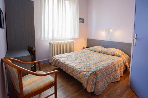 a small bedroom with a bed and a chair at Hôtel du Ladhof in Colmar