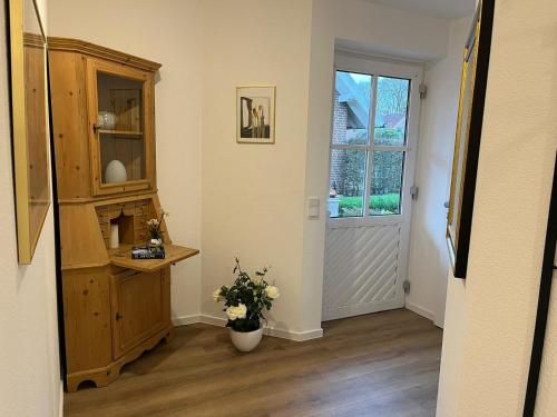 a hallway with a door and a vase of flowers at Appartement Gartenglück in Nordhorn