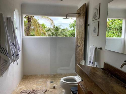 łazienka z toaletą i oknem w obiekcie Villa en Barú con playa privada 6BR w mieście Isla Barú