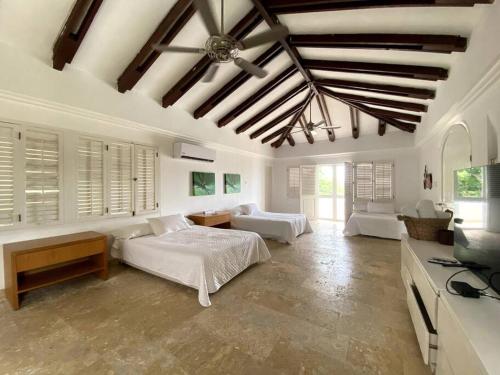 a bedroom with two beds and a living room at Villa en Barú con playa privada 6BR in Baru