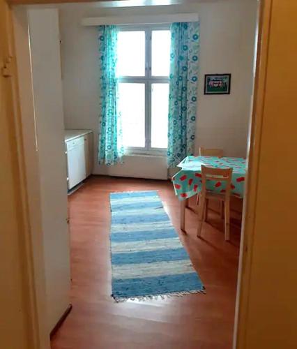 uma sala de estar com uma mesa e um tapete azul em Maaseutumajoitus, Kesti-Iivarin Majatalo em Ylistaro