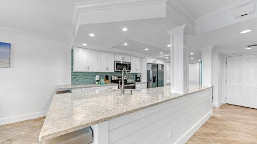a kitchen with white cabinets and a large counter top at Inlet Reef 607 - Beach Front and Spacious with Free Beach Service in Destin