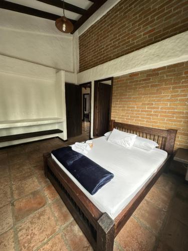 サレントにあるHotel Boutique Villa Isabelのレンガの壁に大きなベッドが備わるベッドルーム1室が備わります。