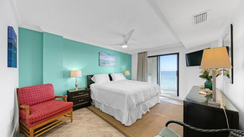 ein Schlafzimmer mit einem Bett und einem Stuhl und einem Fenster in der Unterkunft Inlet Reef 607 - Beach Front and Spacious with Free Beach Service in Destin
