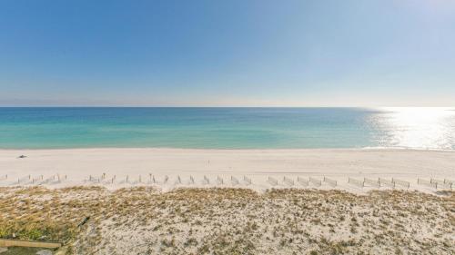 a beach with a bunch of chairs and the ocean at Inlet Reef 607 - Beach Front and Spacious with Free Beach Service in Destin