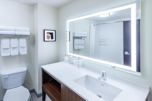 a white bathroom with a sink and a mirror at Holiday Inn Hotel & Suites Tulsa South by IHG in Tulsa